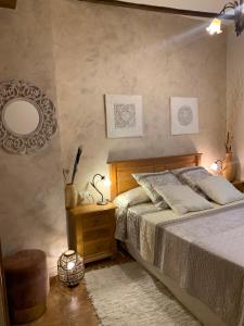 a bedroom with a bed with a mirror and a stool at Casa Rural Valle del Palancia in Castellnovo