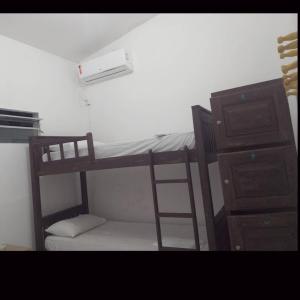 a bedroom with a bunk bed with a ladder and a cabinet at Hostel Central in Maragogi