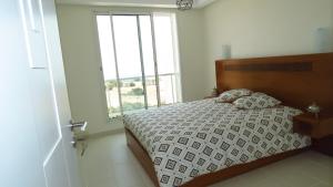 una camera da letto con un letto e una grande finestra di Duplex Taghazout Ocean with pool & fitness a Taghazout Altre 31 foto