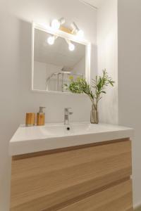 a bathroom with a white sink and a mirror at City center nearby the beach +3Bed +2Bath +Wifi in Las Palmas de Gran Canaria