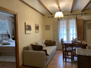 a living room with a couch and a dining room at Casa Rural Valle del Palancia in Castellnovo