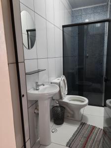 a bathroom with a toilet and a sink and a shower at Hotel Vila Maria in Sao Paulo