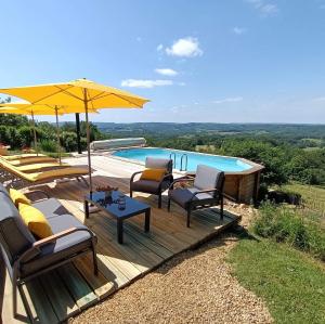 een terras met stoelen, een parasol en een zwembad bij La Maison Bleue in Juillac