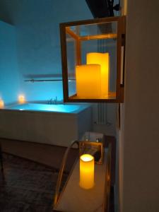 La salle de bains est pourvue d'une baignoire et d'une table avec une bougie. dans l'établissement Il Sitarein, à Bologne