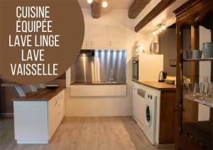 uma cozinha com armários brancos e um forno com placa de fogão em Le gîte du chateau dans le centre de schirmeck em Schirmeck