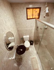 a bathroom with a toilet and a mirror at Pousada Ilha Bella in Fernando de Noronha