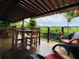 a wooden deck with a table and chairs on it at Pousada Ilha Bella in Fernando de Noronha