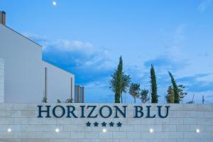 a sign for a hotel with a sign for horizon blyu at Horizon Blu Boutique Hotel in Kalamata