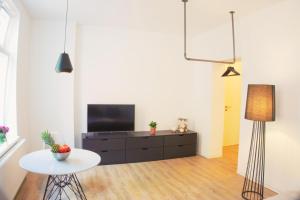 a living room with a tv and a table at Studiowohnung 1 in Buxtehude in Buxtehude