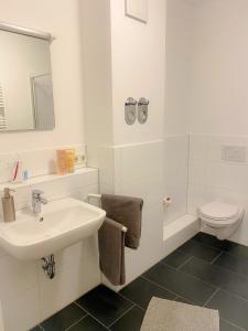 ein weißes Badezimmer mit Waschbecken und Toilette in der Unterkunft Studiowohnung 1 in Buxtehude in Buxtehude + 5 Fotos