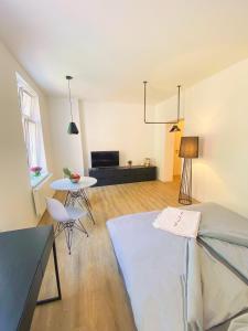 ein Wohnzimmer mit einem Bett und einem Tisch und einem Fernseher in der Unterkunft Studiowohnung 1 in Buxtehude in Buxtehude