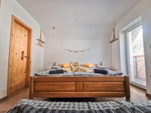 1 dormitorio con 1 cama grande con marco de madera en TriSa apartments Bohinj en Bohinj