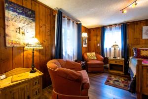 sala de estar con cama y escritorio con silla en Alpen Way Chalet Mountain Lodge, en Evergreen