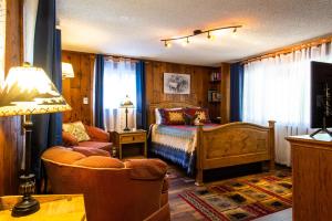 1 dormitorio con 1 cama, 1 sofá y 1 lámpara en Alpen Way Chalet Mountain Lodge, en Evergreen