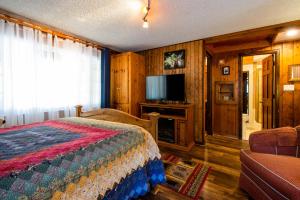 a bedroom with a bed and a flat screen tv at Alpen Way Chalet Mountain Lodge in Evergreen