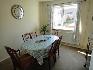 mesa de comedor con sillas y reloj en la pared en 6 Berth House, 2 Bthrm, 2 WC, Parking, Washer, Dryer en Corby