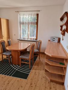ein Esszimmer mit einem Tisch, Stühlen und einem Fenster in der Unterkunft Ferienwohnung Uferblick in Plaue