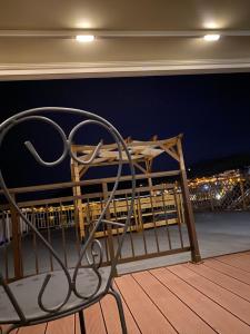 a chair sitting on a balcony at night at Overwave Apartment in Kavála