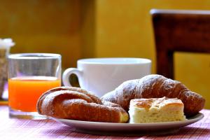 a plate of pastries on a table with a cup of orange juice at La Buonanotte in Mantova