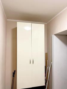 um armário branco no canto de um quarto em Сomfort24 Апартаменти на проспекті Гагаріна Мечнікова Apartment on Gagarina em Dnipro