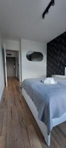 a bedroom with a large bed and a wooden floor at Apartament Nel in Zielona Góra