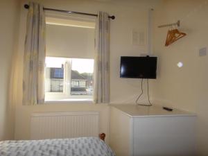 a bedroom with a bed and a television and a window at 6 Berth House, 2 Bthrm, 2 WC, Parking, Washer, Dryer in Corby