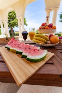 een snijplank met watermeloen en fruit op een tafel bij Domus Mare Cilento in Agropoli