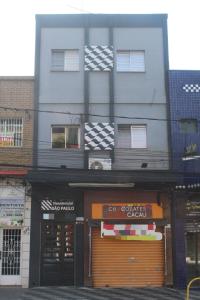 a tall building with a store in front of it at Hotel Econômico ao lado do Metrô in São Paulo
