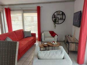a living room with a red couch and a table at The Lighthouse in Middelkerke