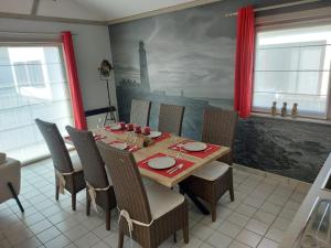 una sala da pranzo con tavolo, sedie e un quadro di The Lighthouse a Middelkerke