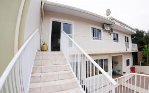 a white house with stairs leading up to it at Casas do Preto in Guarda do Embaú