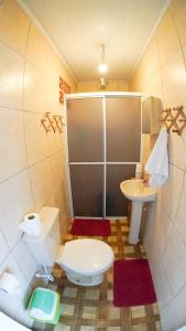 a small bathroom with a toilet and a sink at Casas do Preto in Guarda do Embaú +17 photos