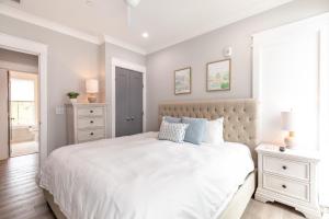 a bedroom with a large white bed and a window at The Magnolia Suite at 124 Spring in Charleston