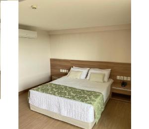 Cond Vista Azul Hotel في بيدرا أزول: غرفة نوم بسرير ذو شراشف ووسائد بيضاء