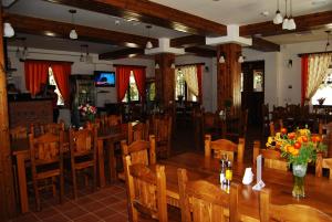 a dining room with wooden tables and chairs at Cabana Conacul Ursului in Cumpăna