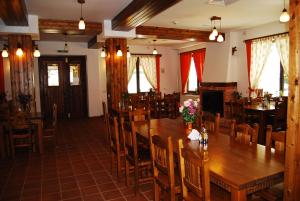 a dining room with wooden tables and chairs at Conacul Ursului in Arefu