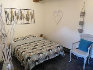 a bedroom with a bed and a blue chair at Séjour à la campagne in Bouhy