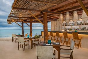 a restaurant on the beach with tables and chairs at Viceroy Villas, Riviera Maya in Playa del Carmen