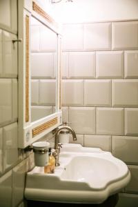 een witte badkamer met een wastafel en een spiegel bij Ungru Guesthouse in Suuresadama
