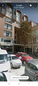 un grupo de coches aparcados delante de un edificio en Departamento Bariloche centro, en San Carlos de Bariloche