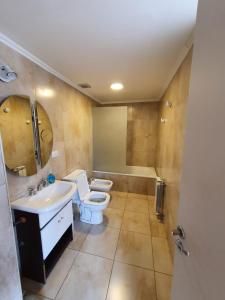 Un baño con inodoro, lavabo y bañera. en Departamento Bariloche centro, en San Carlos de Bariloche