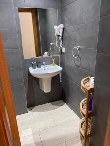 a bathroom with a sink and a mirror at Esmeralda Holidays Apartments in Funchal