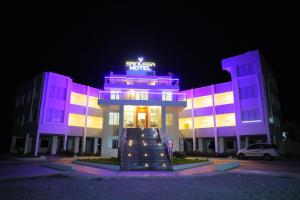 ティルパティにあるSrinivasa Hotelの夜間のホテル看板のある建物
