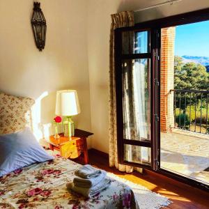 ein Schlafzimmer mit einem Bett und einem großen Fenster in der Unterkunft Finca las Encinas in Ronda