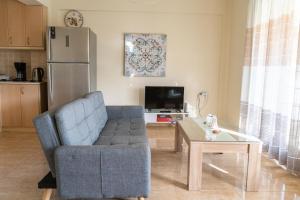 a living room with a couch and a table and a refrigerator at Chalkidiki Develiki Villas in Develíkia