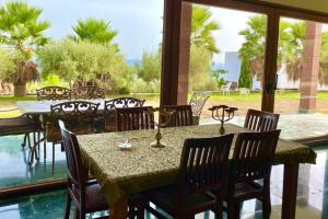 a dining room with tables and chairs and a large window at Alcazaba Hills in Adra