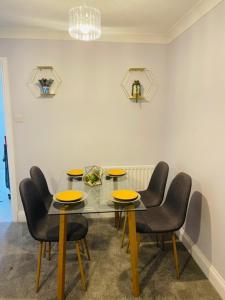 a dining room with a glass table and chairs at Esplanade lodge in Strood