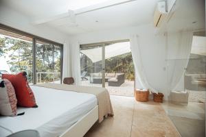 a bedroom with a bed and a large window at Akwa Resorts Ocean View in Santa Teresa Beach