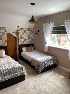 a bedroom with two beds and a window at Stratford House in Stratford-upon-Avon
