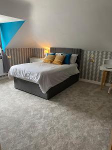 1 dormitorio con 1 cama con almohadas azules y amarillas en Stratford House en Stratford-upon-Avon